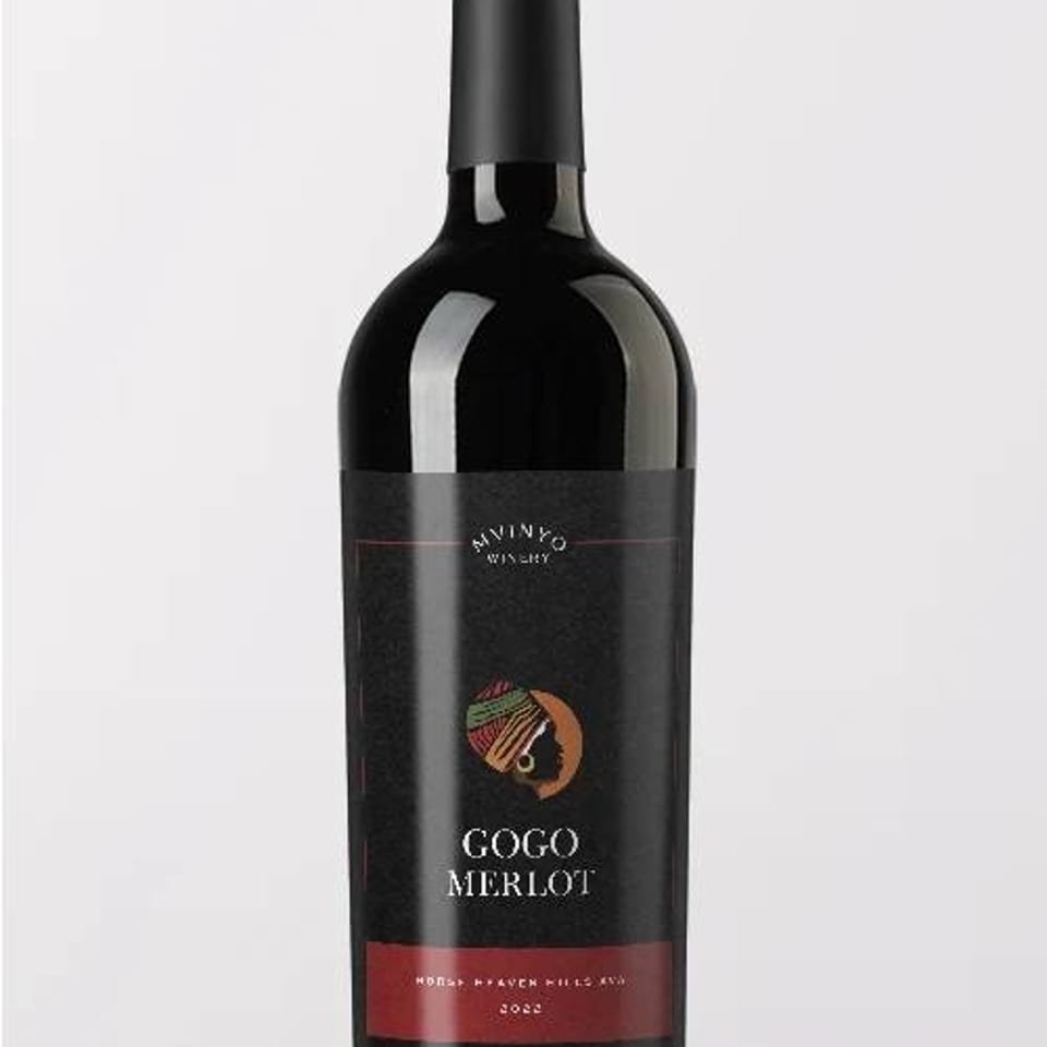Bottle of Gogo Merlot red wine with a black and red label, standing against a light background.